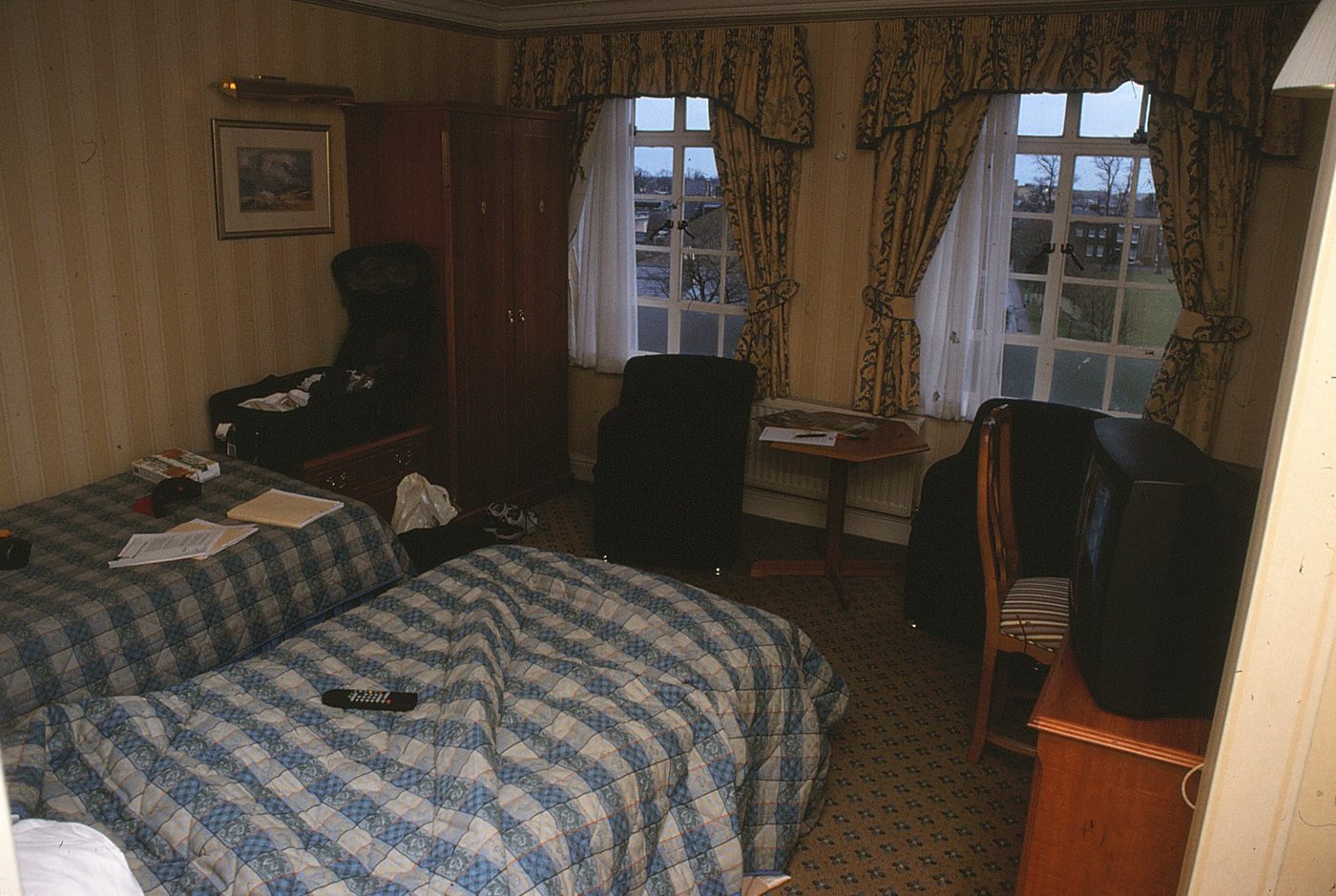 Example hotel bedroom with bed, desk and large window — illustrative only